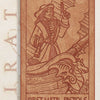 Engraved wooden card from Pirate Tarot by Schiffer Publishing, Ltd., shows a pirate first mate with pistol and sword on a dragon-headed ship. Text: “FIRST MATE–PISTOLS,” “Passion, Charm, Recklessness,” and “PIRATE” in the background.