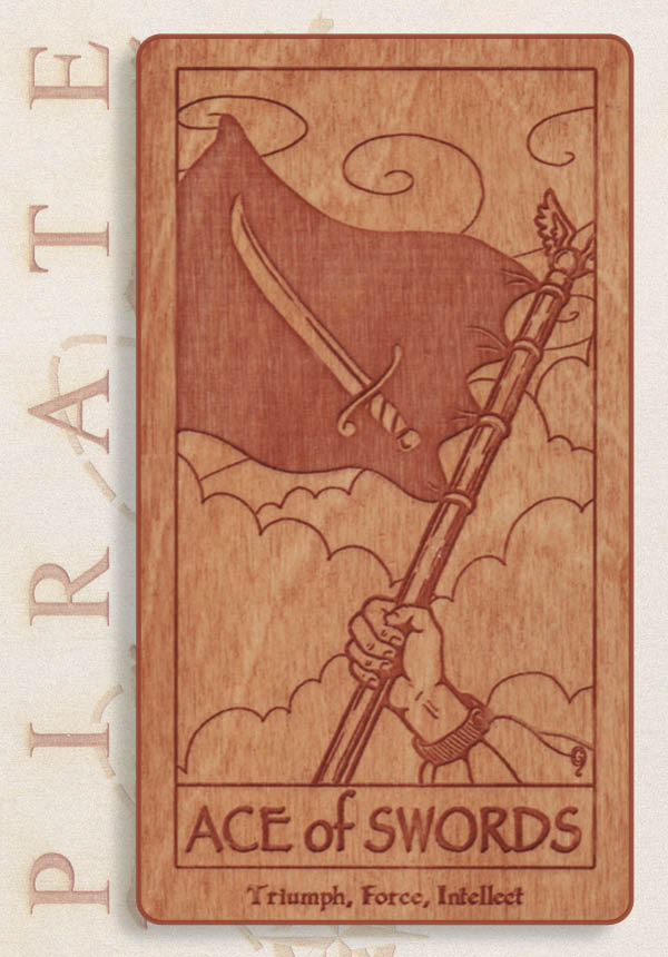 A wooden tarot card from the Pirate Tarot deck by Schiffer Publishing, Ltd. shows a hand with a sword and flag under cloudy skies, with "ACE of SWORDS" and "Triumph, Force, Intellect" inscribed below the image.