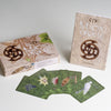 The Māori Oracle by Schiffer Publishing, Ltd. is shown with its box, guidebook, and five fanned-out cards, each displaying unique designs inspired by Māori culture and nature for spiritual guidance in New Zealand.