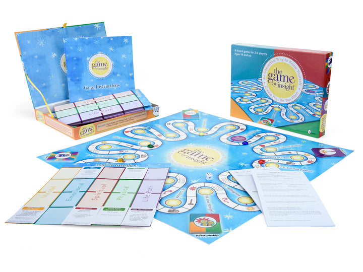 First Light Tarot by Schiffer Publishing, Ltd. is shown with its open board, instruction sheets, 66 Tarot cards, a folded guidebook, and a game box with a yellow and blue design on a white background.