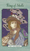 The Enchanted Love Tarot by Schiffer Publishing, Ltd. features the illustrated King of Shells card, showing a person in a feathered hat holding a shell on a purple background. Labeled The Visionary, it represents insight into relationships.