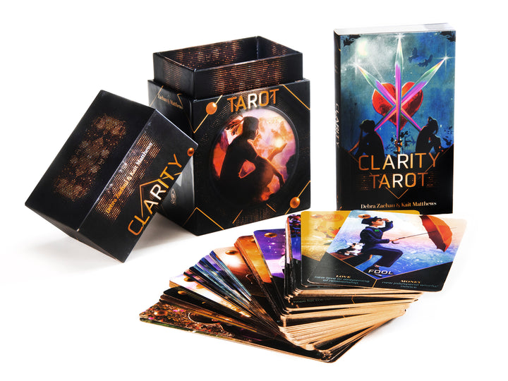 The Clarity Tarot (Deck and Guidebook Box Set) by Schiffer Publishing, Ltd. is shown with its open box and fanned cards, featuring mystical artwork like a central figure and crossed swords—perfect for cartomancy enthusiasts.