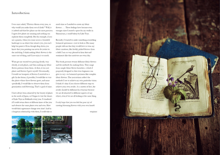 A pair of glasses, a violet flower, and leaves rest on an open book beside Schiffer Publishing, Ltd.'s The Herbarium of Fabric Flowers—an ideal source for inspiring rustic, vintage herbarium fabric projects.