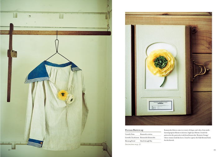 A white sailor-style shirt with blue trim, adorned by a yellow ranunculus, exemplifies wearable plant art. Nearby is "The Herbarium of Fabric Flowers" by Schiffer Publishing, Ltd., echoing the theme of herbarium fabric projects.