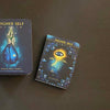 Several illustrated spiritual guidance cards from the Higher Self Oracle by Schiffer Publishing, Ltd. are spread out with their box on a dark surface, featuring designs like a blue teardrop and an eye.