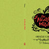 A green cover with swirling patterns and a black apple silhouette features “The Healthy Witch Oracle Cards” by TJ Perkins in red text. Published by Schiffer Publishing, Ltd.; the spine displays the title and author.