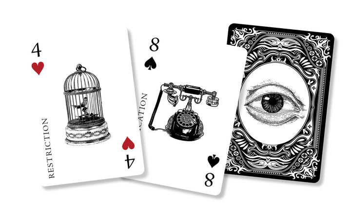 Three playing cards from Inner Eye Oracle by Schiffer Publishing, Ltd. overlap: the 4 of hearts with a birdcage and RESTRICTION, the 8 of spades with a vintage phone and COMMUNICATION, and a card back with an ornate eye.