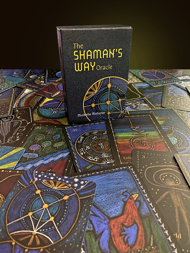A box labeled The Shaman’s Way Oracle by Schiffer Publishing, Ltd. stands upright on illustrated oracle cards, all featuring intricate mystical symbols and vibrant spiritual artwork designed for spiritual healing.