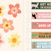 Colorful floral cutouts are on the left, while on the right is Schiffer Publishing, Ltd.'s KindKids Super Awesome Sticker Activity Book featuring animal illustrations and reading-themed messages like “Not now I’m reading” and “It’s a good day to read a book.”.