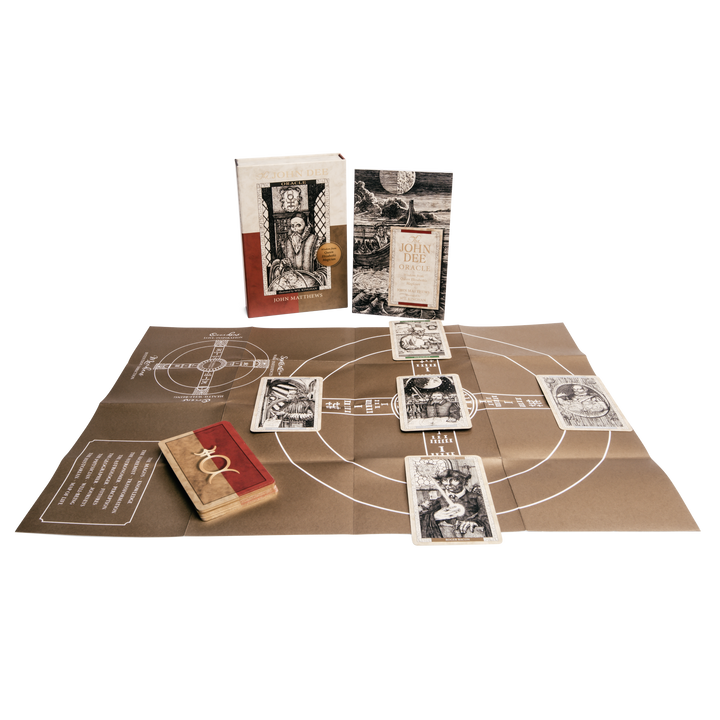 The John Dee Oracle by Schiffer Publishing, Ltd. includes a book, illustrated cards, a brown board with white circles and lines, and a wooden box with a red cover and two gold rings—all displayed on a white background.