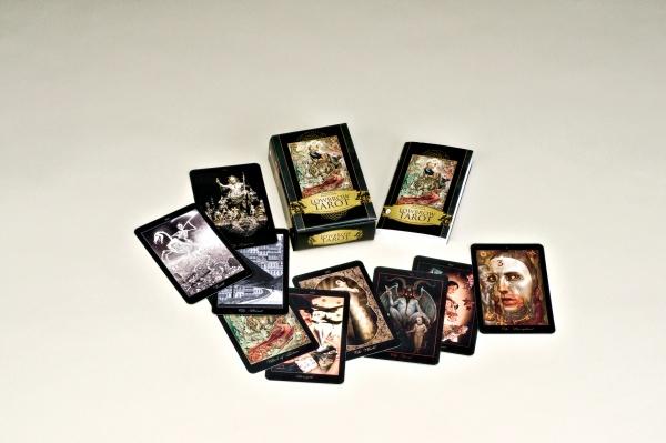 The Lowbrow Tarot by Schiffer Publishing, Ltd. is displayed on a light surface, featuring dark, gothic Lowbrow art. Some cards are fanned out, with the Major Arcana deck box and a stacked deck in the center.