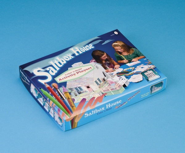The Saltbox House build and color playset by Schiffer Publishing is shown on a blue background with images of two children assembling the paper model house, colored pencils, and illustrations of the finished house.