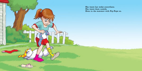 A young girl smiles outdoors as she puts on socks from Jocelyn's Box of Socks by Schiffer Publishing, Ltd. Nearby, a cat in scarf and socks lounges—the perfect scene to inspire children's stories about friendship and emotions.