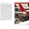 An aircraft assembly hangar features multiple large passenger planes, including an Airbus A300/310 with a red tail by Schiffer Publishing, Ltd., and another with a dark blue and red tail amid scaffolding and construction equipment.