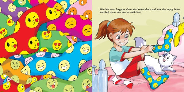A girl smiles on her bed as she puts on Jocelyn's Box of Socks from Schiffer Publishing, Ltd.—colorful socks with emoji faces—while a white cat plays nearby and a pile of vibrant socks is shown on the left.