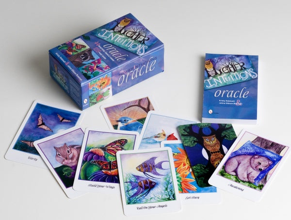 The Higher Intuitions Oracle by Schiffer Publishing, Ltd. features vibrant animal oracle cards spread beside their blue box and guidebook, ready to offer spirit-inspired guidance.